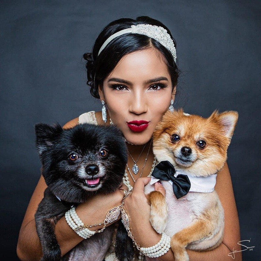 Sweet sixteen quinceranera portrait of a young girl hugging her two dogs.