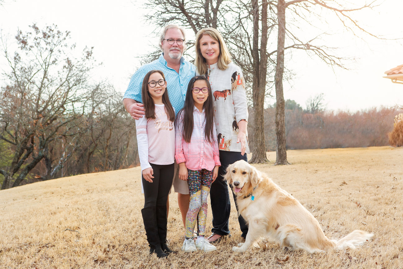 Outdoor family portrait with their golden retriever.