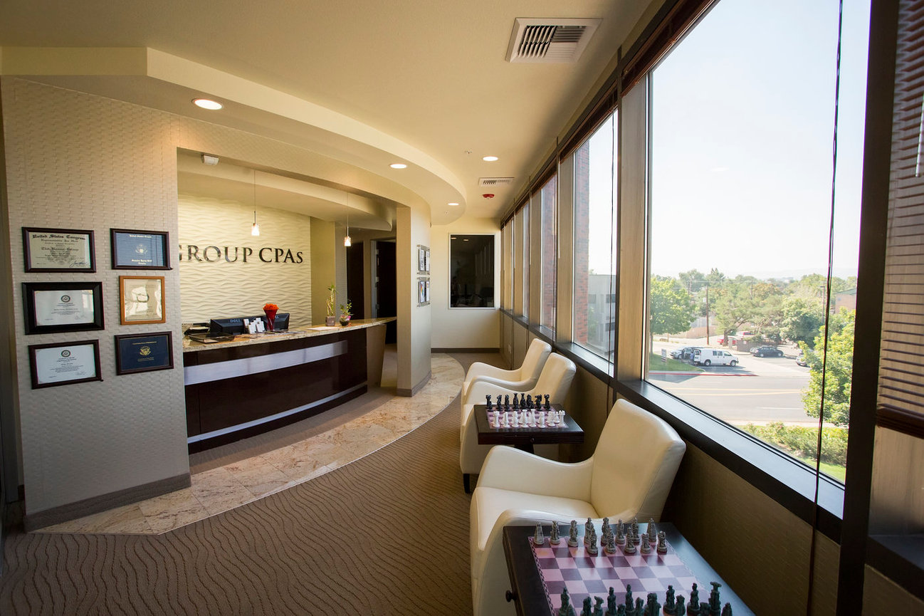Real estate and branding photo of Interior waiting area view of commercial office showcasing dramatic curved wall and opposite window view to grounds below.