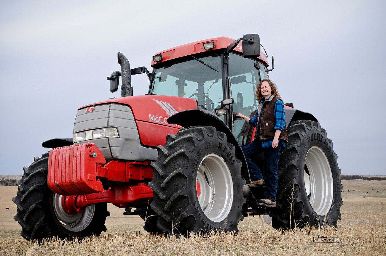 The female owner of 88 Hay standing on the step of her McCormick tractor.