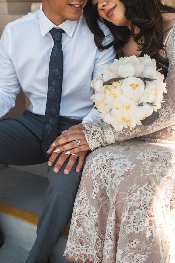 Couple sitting holding hands with a bouquet