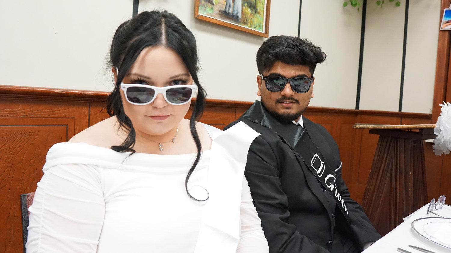 Bride and groom wearing sunglasses at a wedding reception